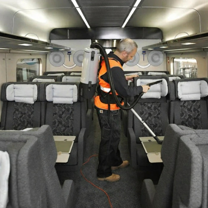 Operator wearing Nilfisk GD5 HEPA commercial backpack vacuum cleaner built for ergonomic use and superior filtration in commercial spaces