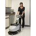 Operator using Nilfisk SC351 walk-behind compact floor scrubber for deep cleaning of hard surfaces