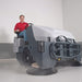Operator using Nilfisk SW8000 diesel powered industrial ride-on sweeper for powerful sweeping performance in commercial and industrial facilities